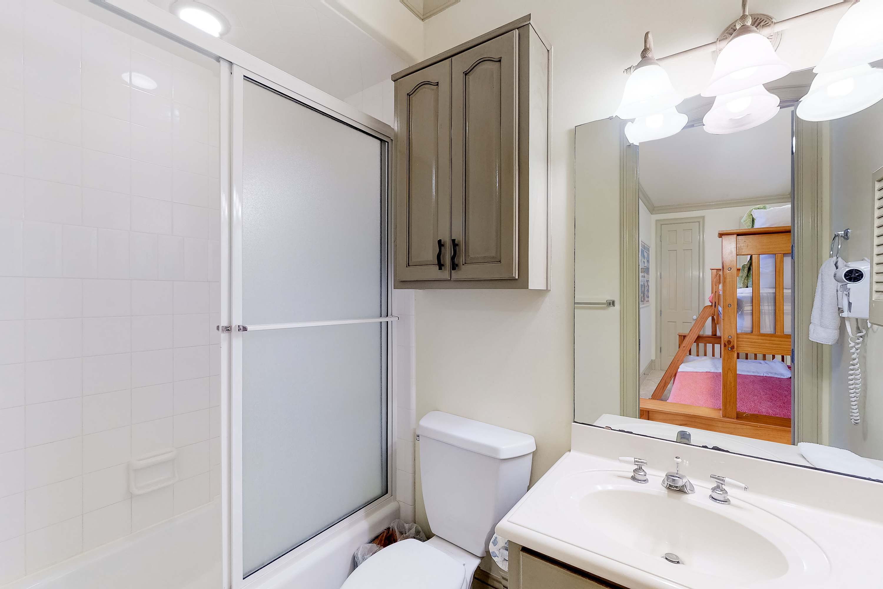 Une salle de bain avec douche, toilettes et lavabo.