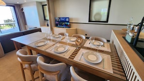 A dining area with a glass table, striped placemats, and wicker chairs. - VILLA BEAUMER - Beach Access . Sea view - TK60 (Carnac)