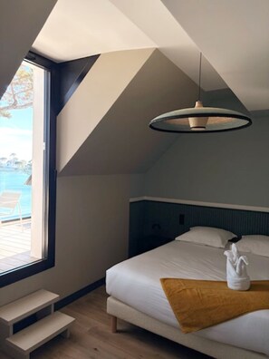 A bedroom with a bed, a view of the outdoors, and a skylight. - VILLA BEAUMER - Beach Access . Sea view - TK60 (Carnac)