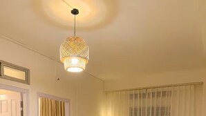 Ein Wohnzimmer mit einer Couch, zwei Sesseln, einem Couchtisch und einer Pendelleuchte.
