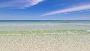 A clear view of a beach with calm waters and a clear sky.