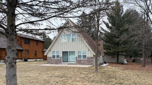Une maison à deux étages, dotée d’une façade en pierre et d’un toit à pignon.