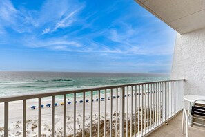 A balcony with a view of the beach, white railing, and a table. - Sixth-Floor Oceanfront Condo with washer&dryer, Central AC, pool (Miramar Beach)