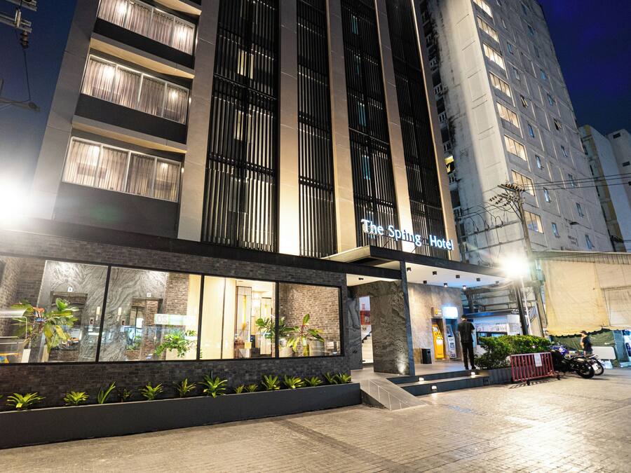A hotel entrance with a modern facade, large windows, and a well-lit entrance area.