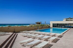 Ein Poolbereich mit Liegestühlen und Blick auf den Ozean.