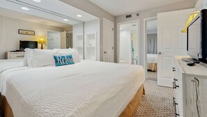 A hotel room with a large bed, a television, a desk with a lamp, and a wardrobe. - 15th Floor Stunning Condo, Splash pad w multiple pools & hot tub (Destin)