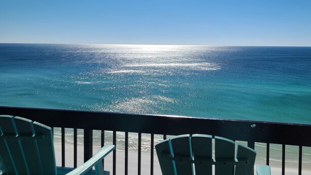 A balcony with two chairs overlooking a beach and the ocean. - 15th Floor Stunning Condo, Splash pad w multiple pools & hot tub (Destin)