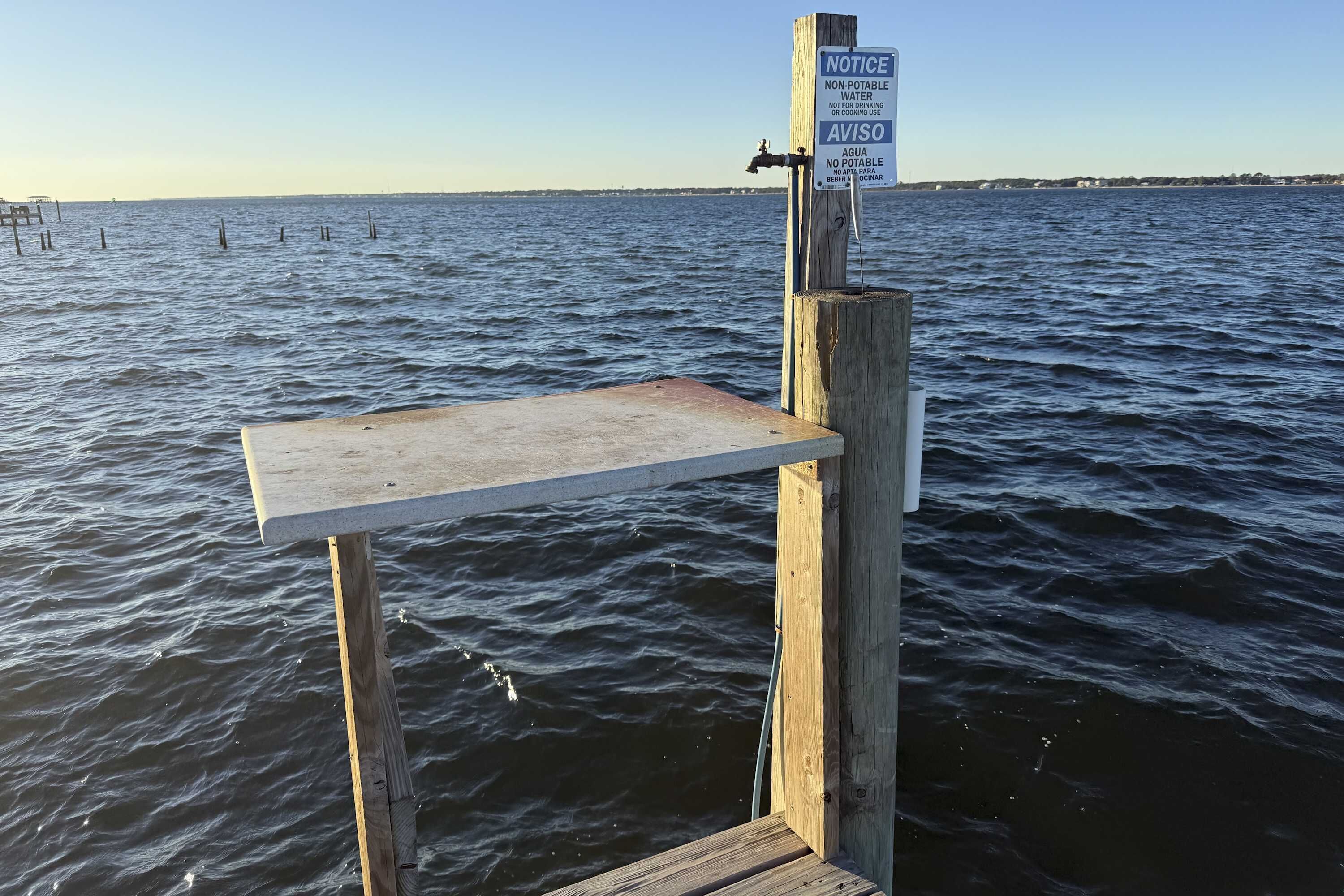 Eine Holzstege mit einem Schild, das angibt, dass das Wasser nicht trinkbar ist.