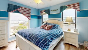 A bedroom with a bed, nightstands, a ceiling fan, and a window with curtains. - Sound view townhome with balcony, alfresco dining, AC, & W&D - snowbird-friendly (Navarre)