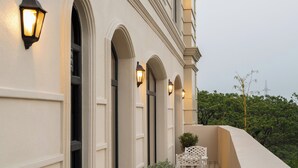 Ein Gebäude mit Bogenfenstern und einem Balkon mit Ziegelbelag.