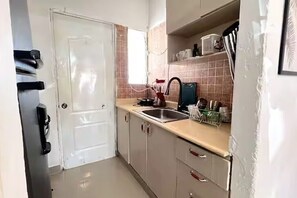 A compact kitchen with a sink, countertop, and cabinets. - Acogedora Villa en Punta Cana (Punta Cana)