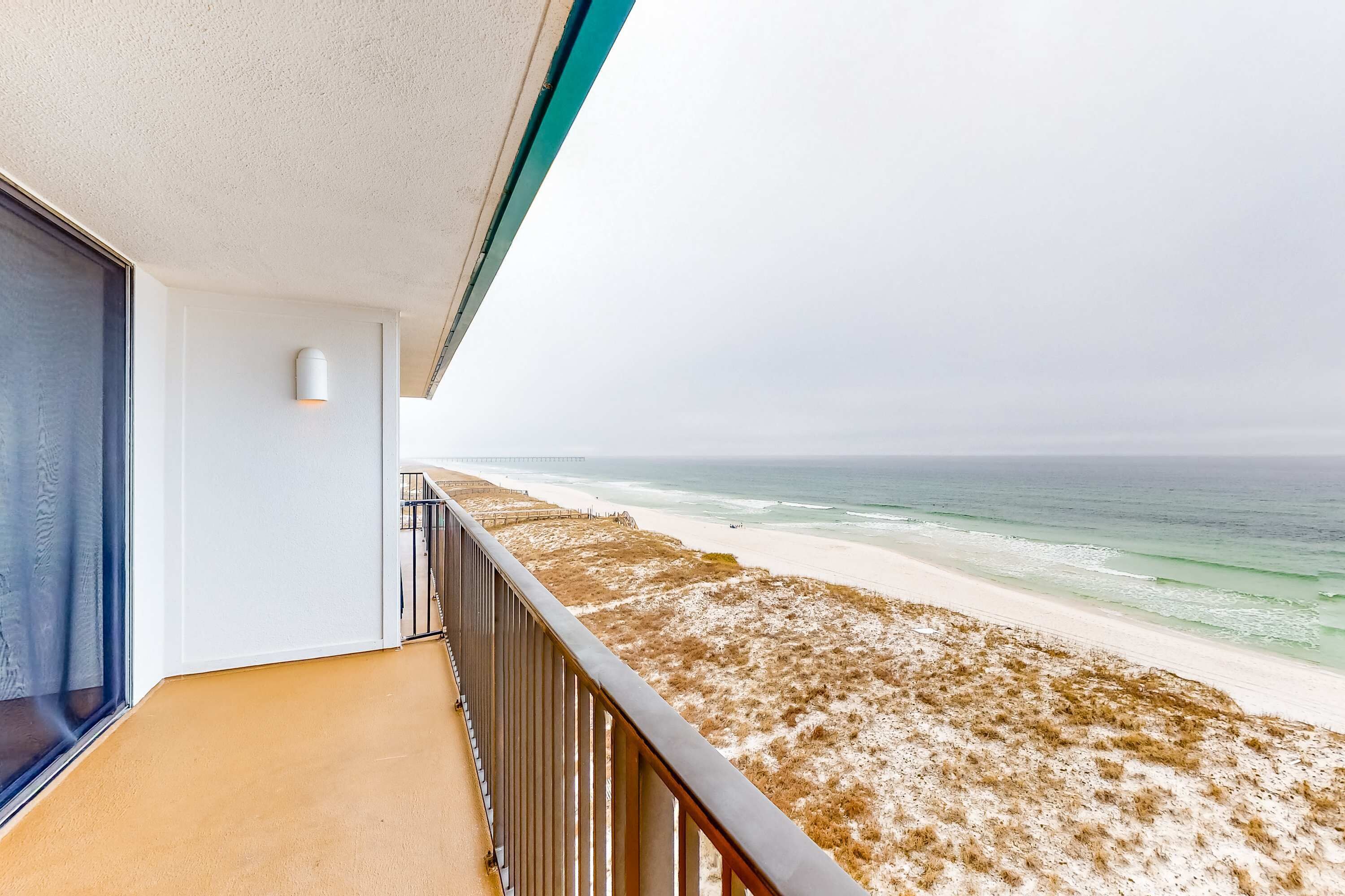 Un balcon avec vue sur la plage et l’océan.