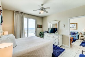 A hotel room with a bed, a ceiling fan, a television, a dresser, and a view of the ocean. - Beautiful gulf front condo w/ocean views, free WiFi, & amenity access (Panama City Beach)