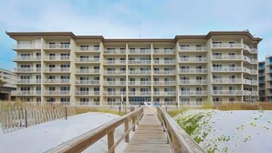 A multi-story hotel with balconies and a wooden walkway leading to the beach. - Sixth floor Summer Place condo w beach access, shared pool, and more (Fort Walton Beach)