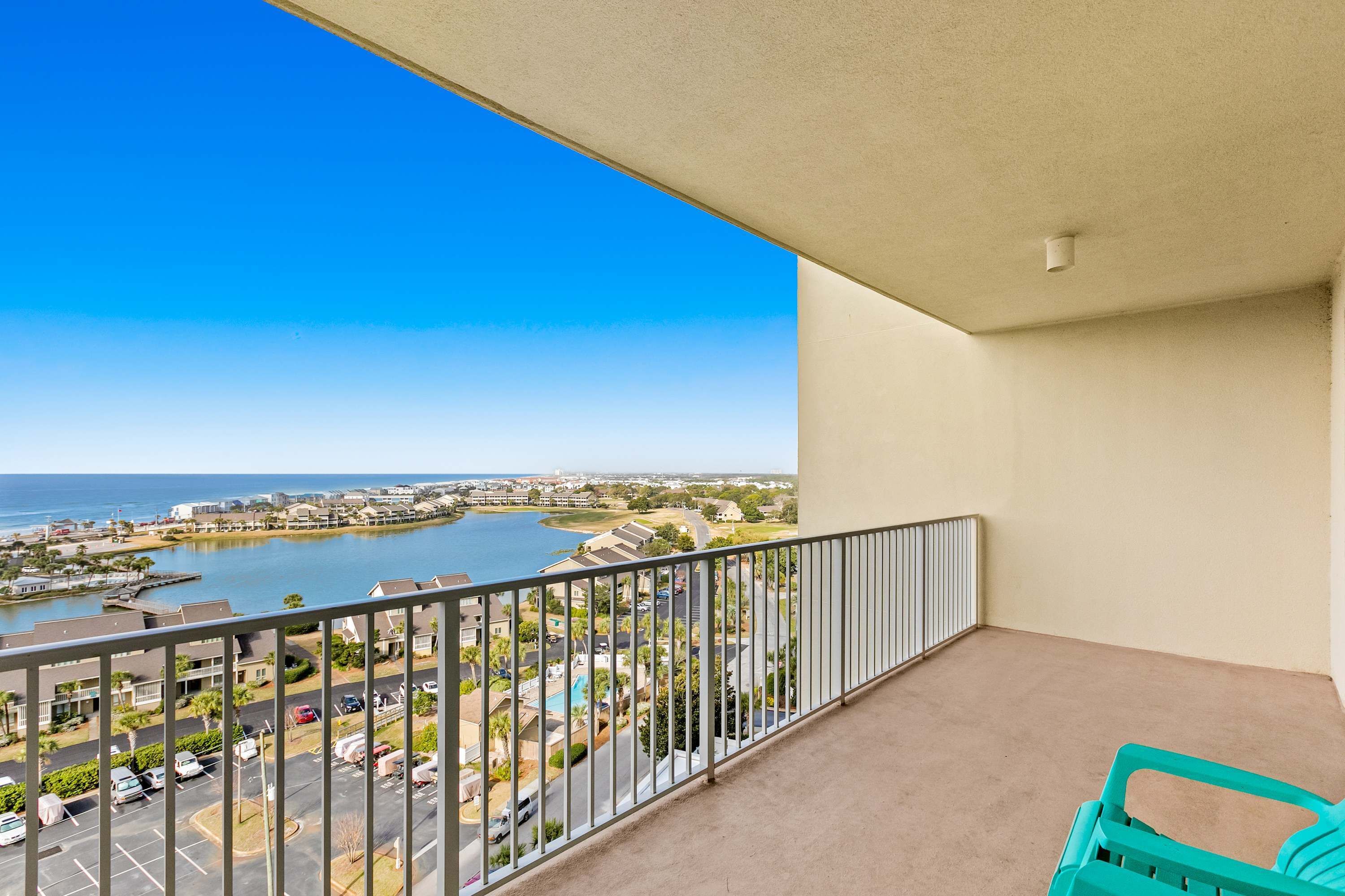 A balcony with a view of a body of water and surrounding buildings.