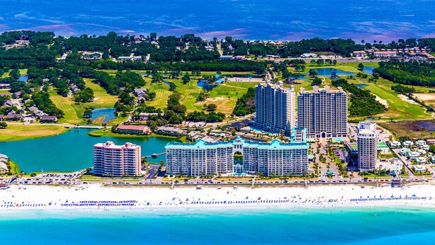 Um resort costeiro com vários hotéis altos, uma praia e um campo de golfe.
