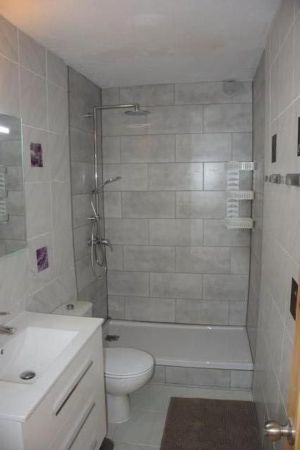 Ein Badezimmer mit Dusche, Toilette und Waschbecken.