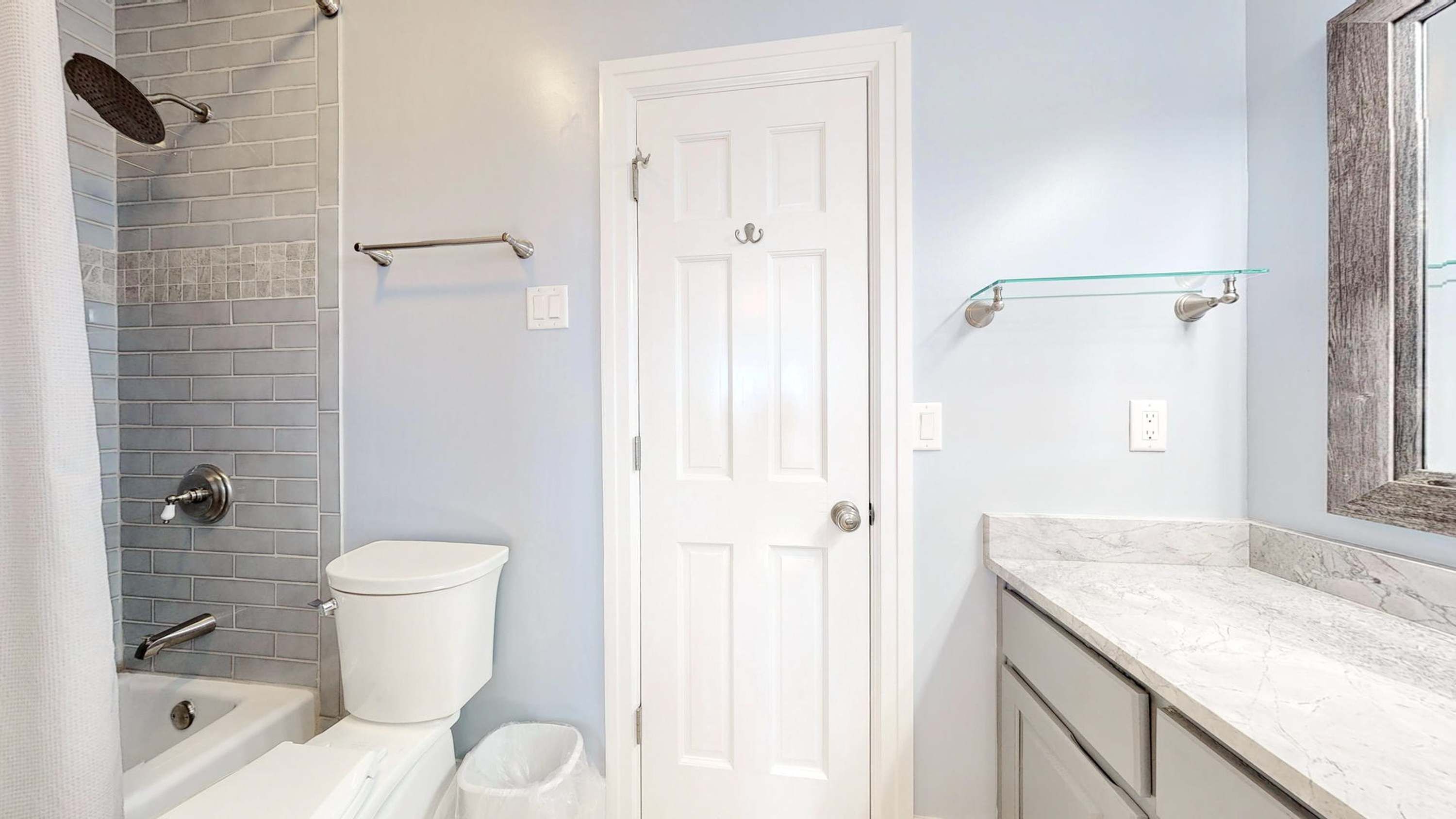 A bathroom with a bathtub, toilet, and sink.