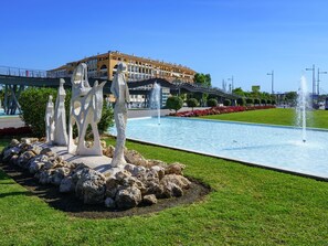 A fountain with sculptures in a landscaped area, a bridge, and a building in the background. - In der Nähe des Strandes, beheiztes Schwimmbad, Spielraum, Spielzimmer, etc by Interhome (Marbella)