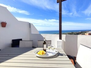 A terrace with a table set for two, a bottle of wine, and a plate of food. - "Casa Valle Niza" mit Pool by Interhome (Almayate Bajo)