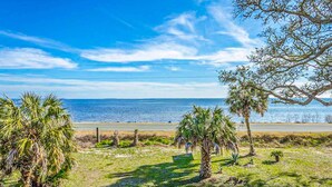 A coastal landscape with a clear sky, palm trees, and a view of the ocean. - Dog-friendly home with lovely water view, roomy deck, fast WiFi, central AC, W&D (Eastpoint)