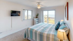 A bedroom with a bed, a television, a ceiling fan, and a window with a view. - Dog-friendly home with lovely water view, roomy deck, fast WiFi, central AC, W&D (Eastpoint)