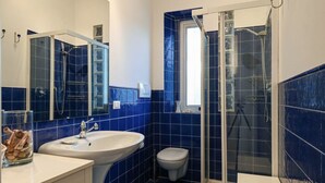 A bathroom with a large sink, toilet, and glass-enclosed shower. - Villa Oliva 8 - Carraro Immobiliare Jesolo (Lido di Jesolo)