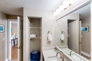 Un baño moderno con un espejo grande, un lavabo y un perchero para toallas.