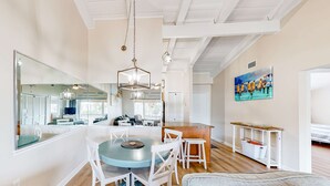 Une cuisine moderne avec un îlot central, des chaises blanches et une table à manger.