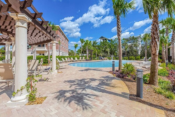 A pool area with lounge chairs and palm trees. - Peaceful studio with pool, convenient kitchenette, beach access & WiFi (Rosemary Beach)