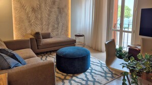 Ein modernes Wohnzimmer mit einer Couch, einem Hocker und einem gemusterten Teppich.