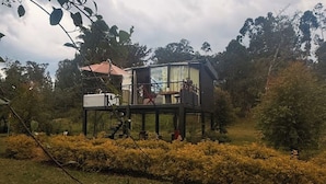 A modern house with a deck, surrounded by greenery. - Dome with Private Jacuzzi in Villa de Leyva - Nature & Relaxation (Boyacá)