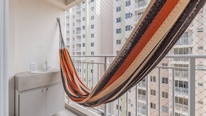A hammock in a balcony with a view of a residential building. - Mirante #801 - Two Bedroom Apt by Carpediem (Fortaleza)