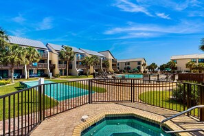 A hotel with multiple swimming pools, a well-maintained lawn, and a clear blue sky. - Oceanfront Largo Mar Home w/ a Private Balcony plus Free WiFi & Beach Access (Panama City Beach)