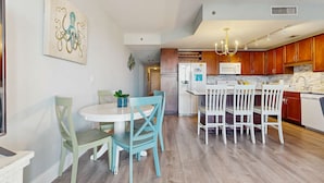 Een moderne keuken met houten kastjes, een witte koelkast en een marmeren aanrecht.