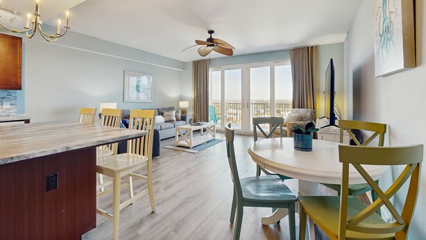 Een moderne woonkamer met een eethoek, een keuken en een balkon met uitzicht.