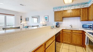 Una cocina moderna con armarios de madera, una isla grande, un microondas y un lavavajillas.