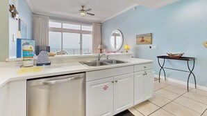 A modern kitchen with a dishwasher, double sink, and a ceiling fan. - Gulf front penthouse w shared pools, snack shack, community grill & more (Destin)