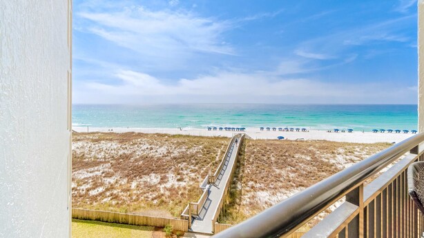 A beach view from a balcony with a wooden deck and a railing. - Spacious fourth-floor condo - Complimentary BEACH SERVICE (Navarre Beach)