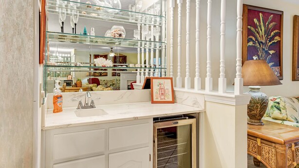 A modern bathroom with a glass-fronted vanity, a built-in dishwasher, and a decorative mirror with a white railing. - Conveniently located condo with shared pool & tennis, on-site golf - walk to beach (Panama City Beach)
