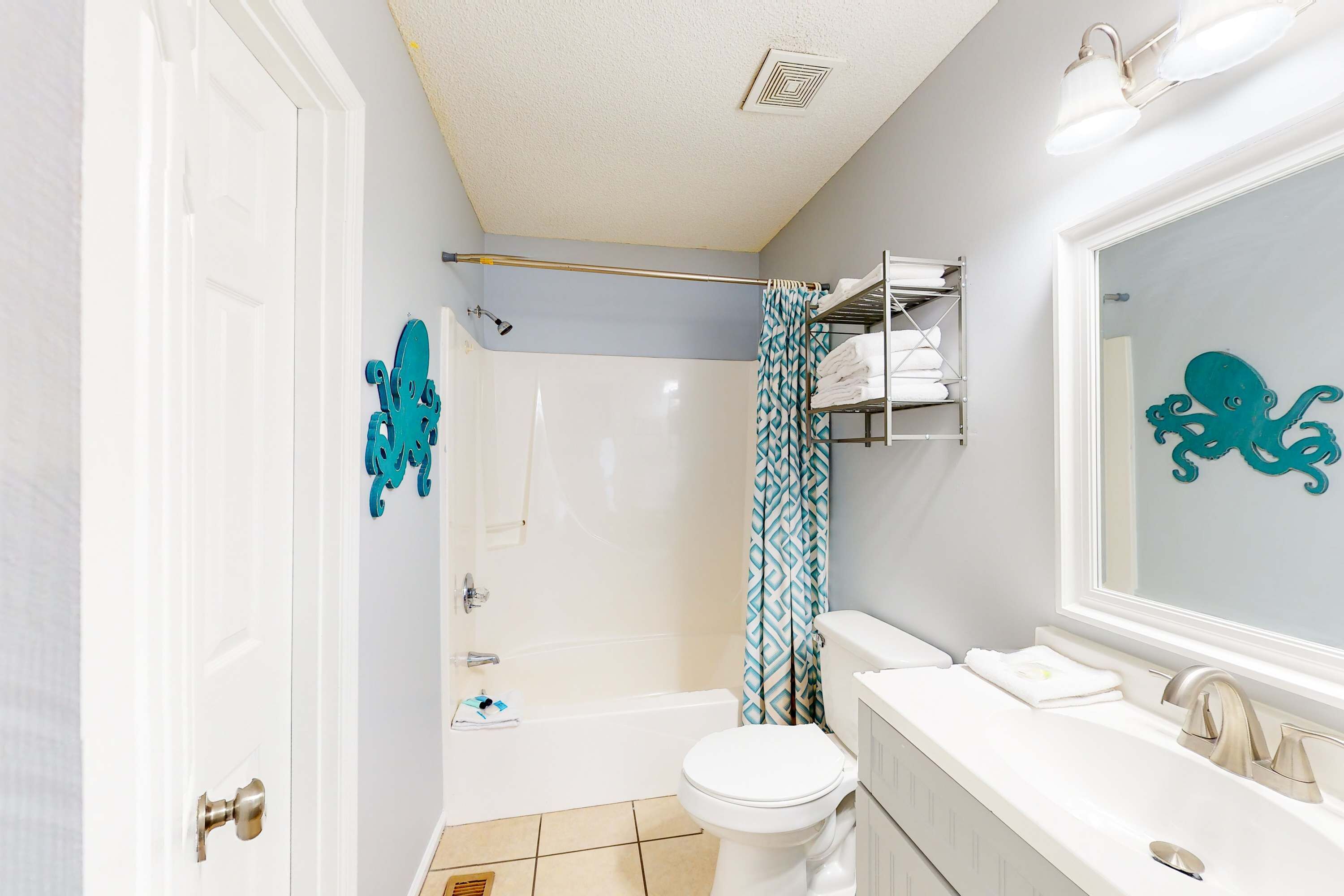 A bathroom with a shower, toilet, and sink.