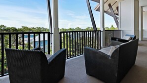 A balcony with wicker furniture and a view of a residential area. - Stunning condo with washer/dryer, pool & convenient beach access (Santa Rosa Beach)
