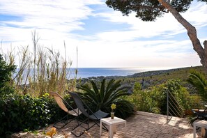 A patio with chairs and a table, overlooking a coastal landscape. - Holiday Home 'Les Cigales' with Private Terrace, Wi-Fi and Air Conditioning (Cassis)