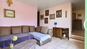 Ein Wohnzimmer mit einer Couch, einem kleinen Tisch, einem Schrank und Wanddekorationen.