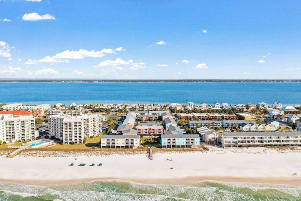 A coastal hotel with multiple buildings, a beach, and a view of the sea.