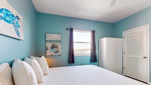 Une chambre à coucher avec un grand lit, une armoire et une fenêtre avec des rideaux.