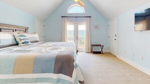 A bedroom with a bed, a ceiling fan, a window, and a door. - Spacious home with  shared pool, large kitchen and close to beach (Pensacola Beach)