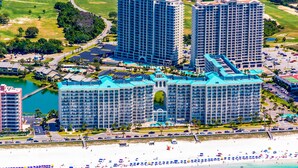 Ein großer Hotelkomplex mit mehreren Hochhäusern, einem Strand und einer Marina.
