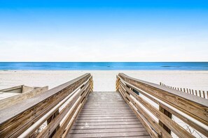 A wooden boardwalk leading to a beach with a clear blue sky. - Gorgeous beachfront condo, shared pool and beach access (Fort Walton Beach)