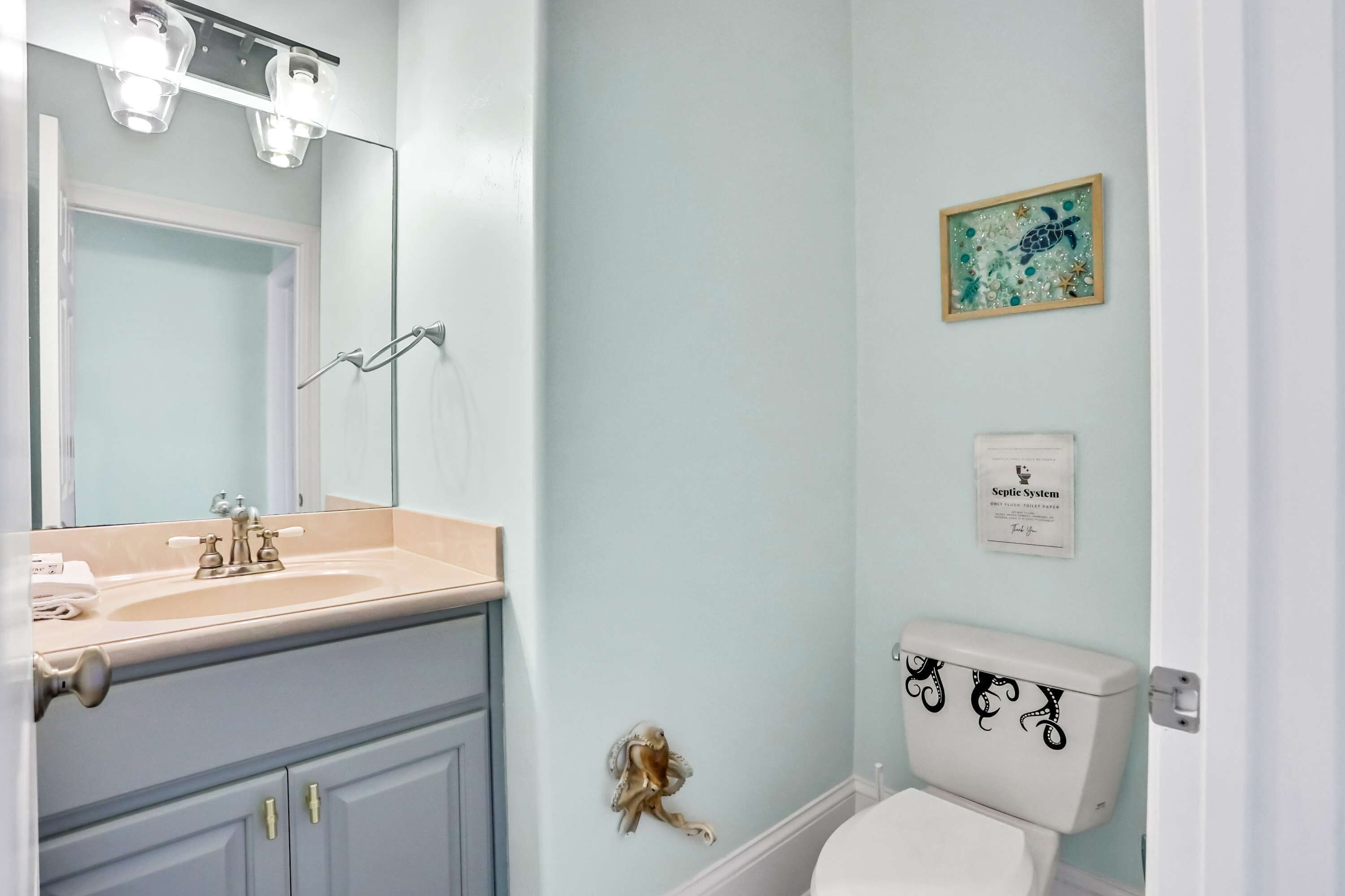 A bathroom with a sink, mirror, and toilet.